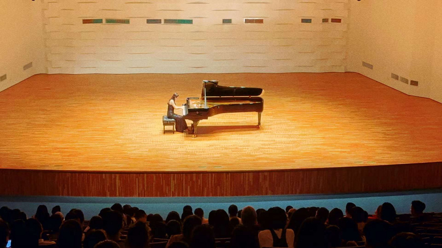 A person sitting at a podium in front of a crowdDescription automatically generated with low confidence